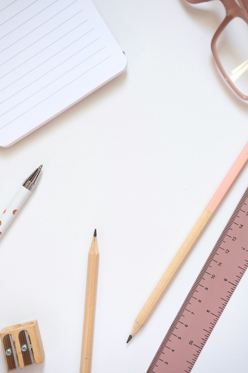 Quaderno e cancelleria ordinatamente disposti su una scrivania bianca.